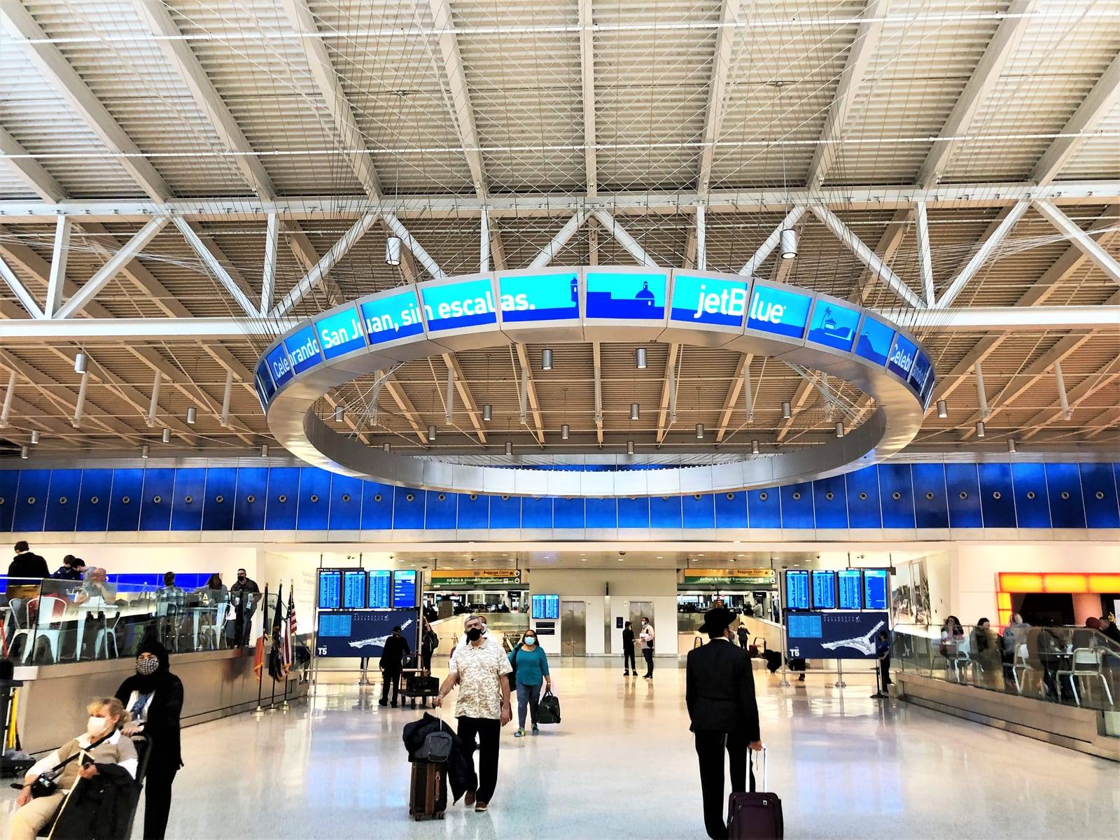 The JFK Terminal 5 departures hall, with JetBlue’s circular screen hanging above the concourse