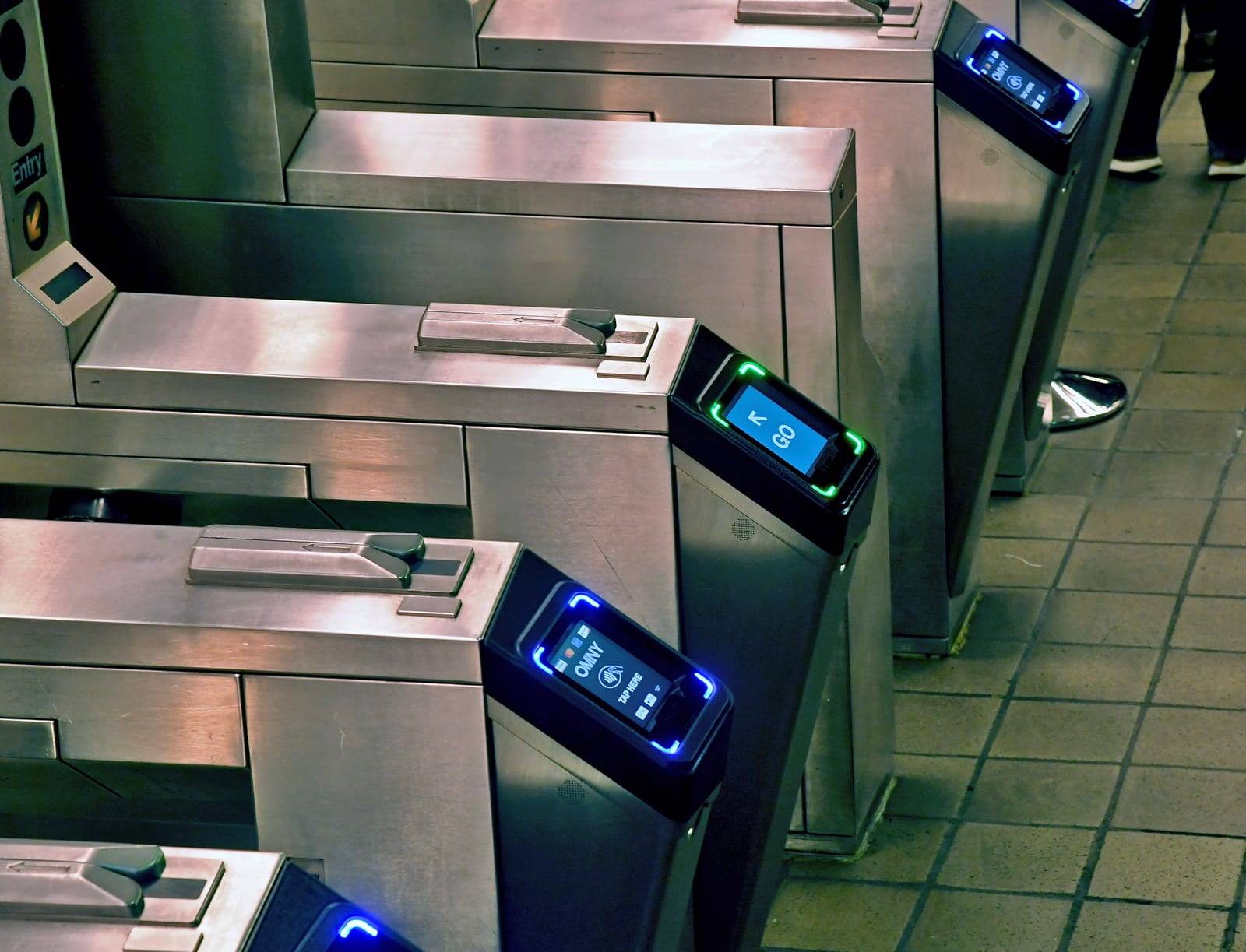 A contactless OMNY reader at a New York subway turnstile, the tap target for the $3.00 fare